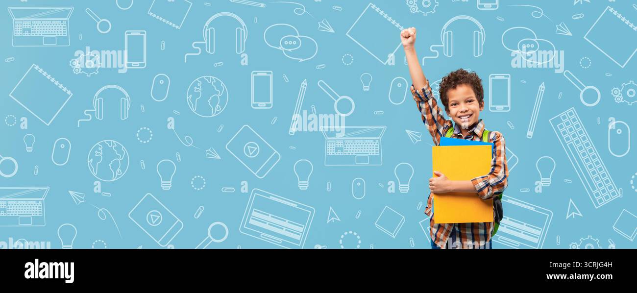 Enfant souriant avec des fournitures scolaires en main contre un fond éducatif bleu Banque D'Images