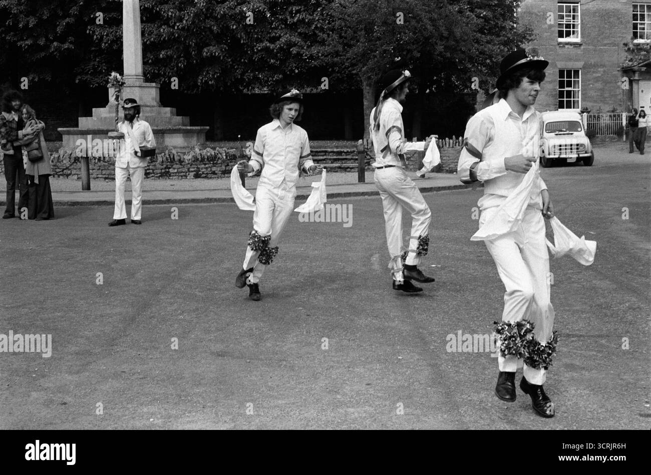 Bampton Morris danse une tradition anglaise. ( Rituel d'une épée placée à travers un gâteau aux prunes, une petite distribution de gâteau est ensuite donnée aux populations locales. Une célébration symbolique de l'arrivée du printemps et de la fertilité de la terre, une célébration du début du printemps et du renouveau Bampton, Oxfordshire Angleterre des années 1975 1970 Royaume-Uni HOMER SYKES Banque D'Images