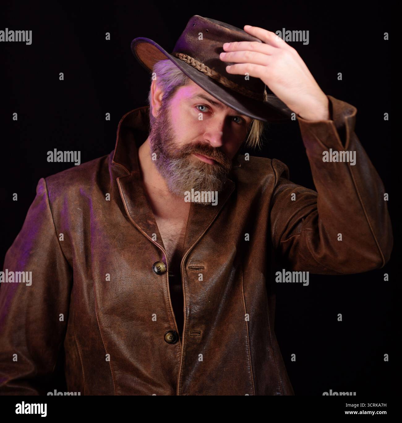 Style cow-boy. Portrait d'un bel homme barbu en chapeau de cow-boy et manteau en cuir. Cow-boy américain. Mode homme dans le style occidental. Macho barbu brutal Banque D'Images