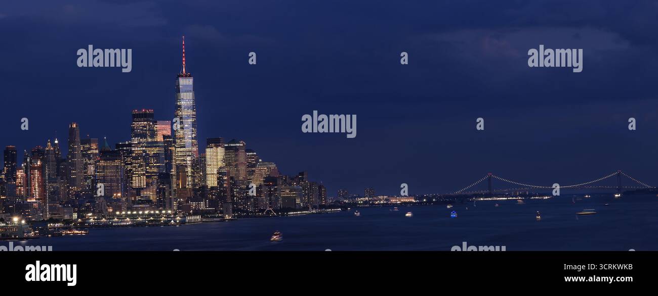 Lower Manhattan illuminé la nuit avec la rivière Hudson au premier plan Banque D'Images