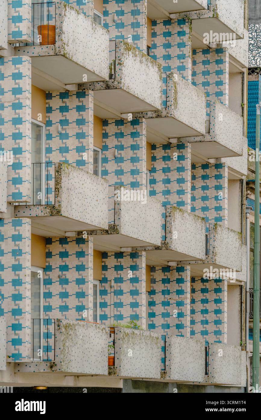 Façade répétitive et abstraite d'un bâtiment résidentiel moderne avec un motif de mosaïque bleue et blanche et de profonds balcons empilés Banque D'Images