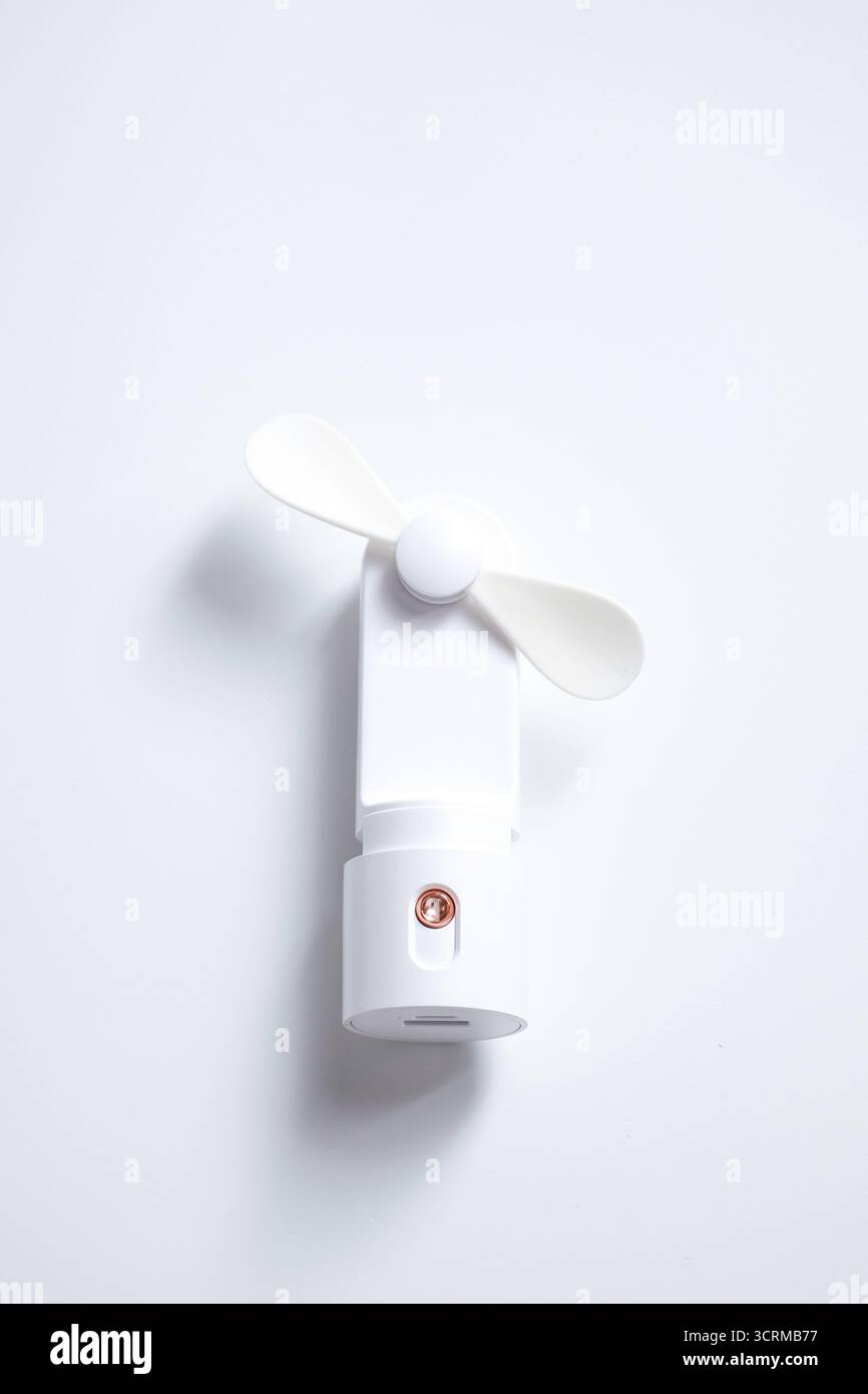 Mini ventilateur électrique avec poignée isolé sur fond blanc Banque D'Images