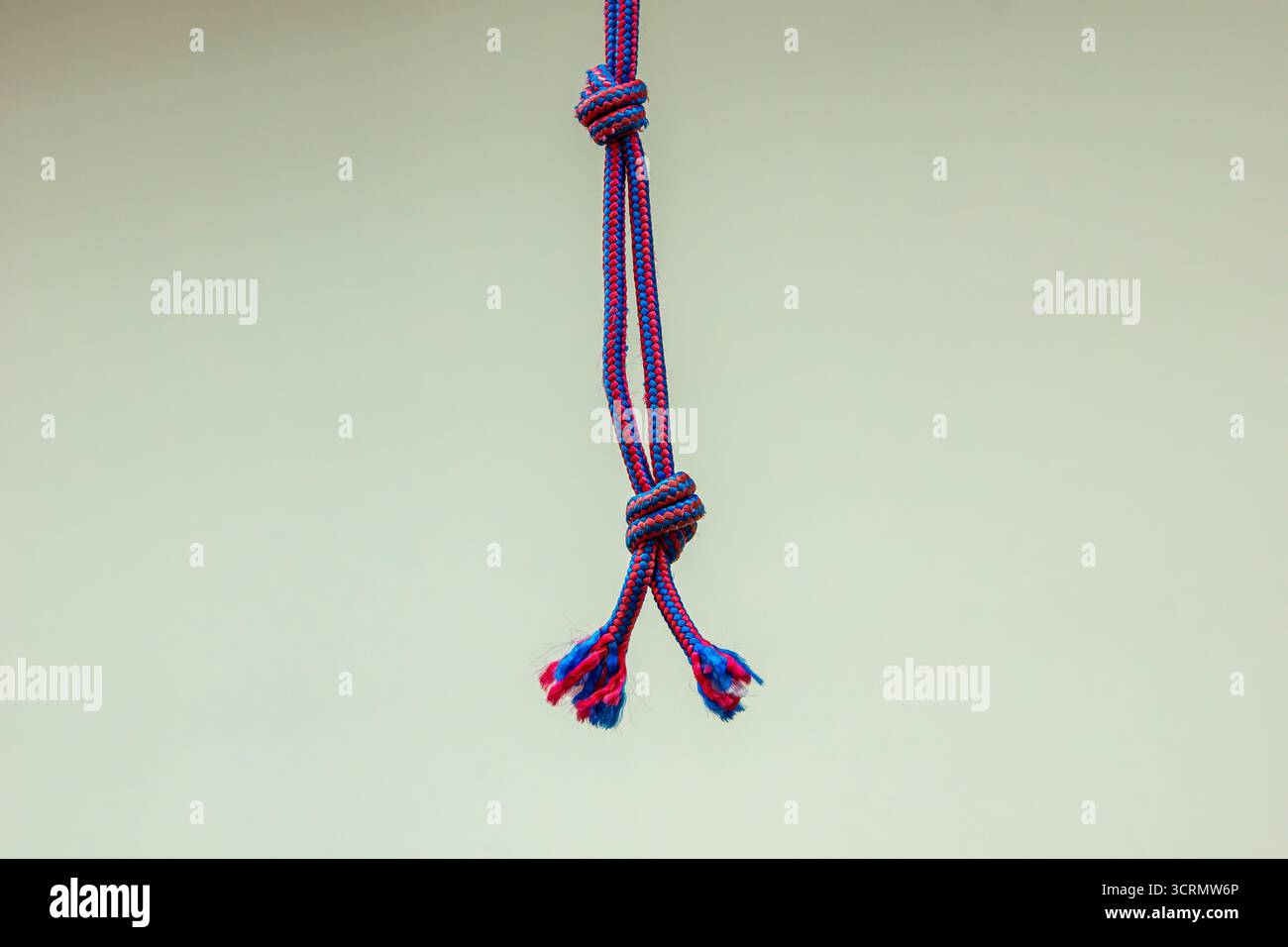 Les extrémités effilochées et les doubles nœuds suggèrent une tension répétée ou un nouage incorrect. Peut entraîner une défaillance sous charge ou nécessiter un remplacement pour des raisons de sécurité. Banque D'Images