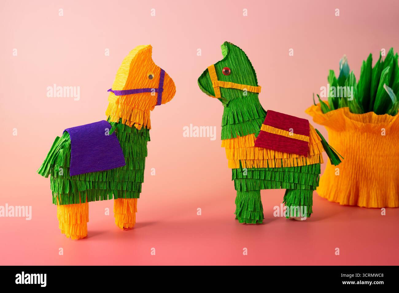 Artisanat coloré en papier fait à la main, y compris un lama piñata, un cactus en papier et des faveurs de fête vibrantes, célèbrent la culture mexicaine et l'esprit festif de Banque D'Images
