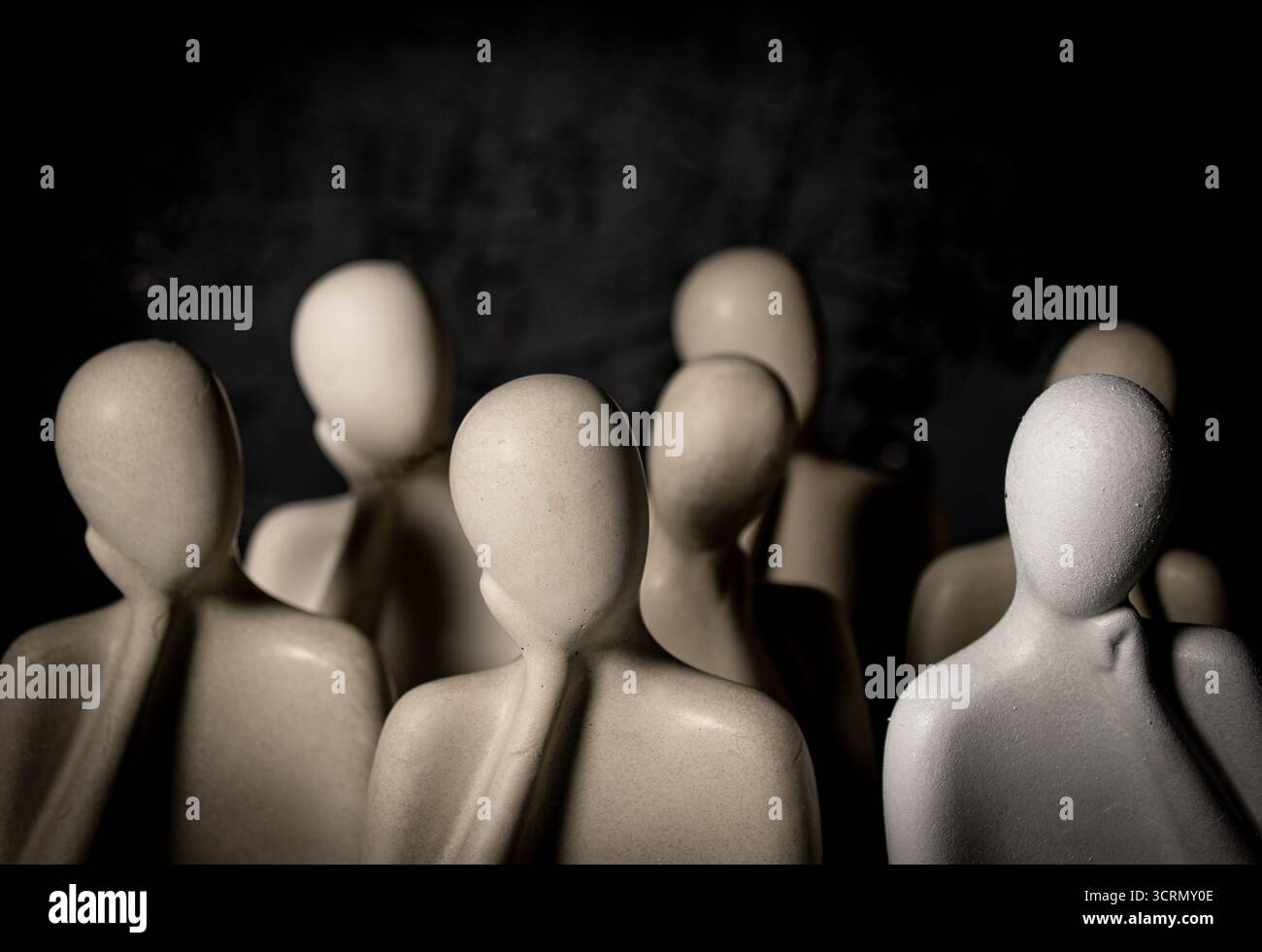 Groupe de figures de gypse blanc sur fond noir. Mise au point sélective. Concept de tristesse. Banque D'Images
