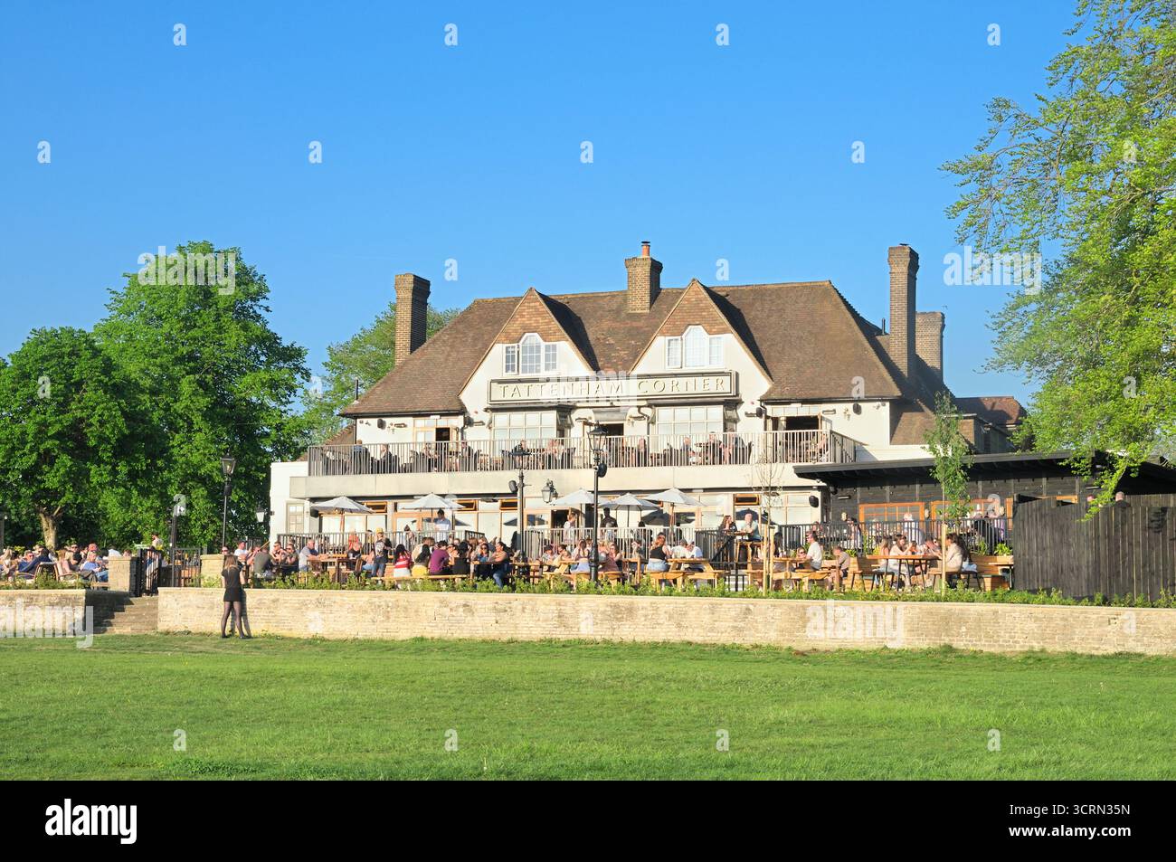 Les gens apprécient les boissons dehors au soleil au pub rénové Tattenham Corner, pubs Young & Co.'s Brewery, Epsom Downs, Surrey, Angleterre, Royaume-Uni Banque D'Images
