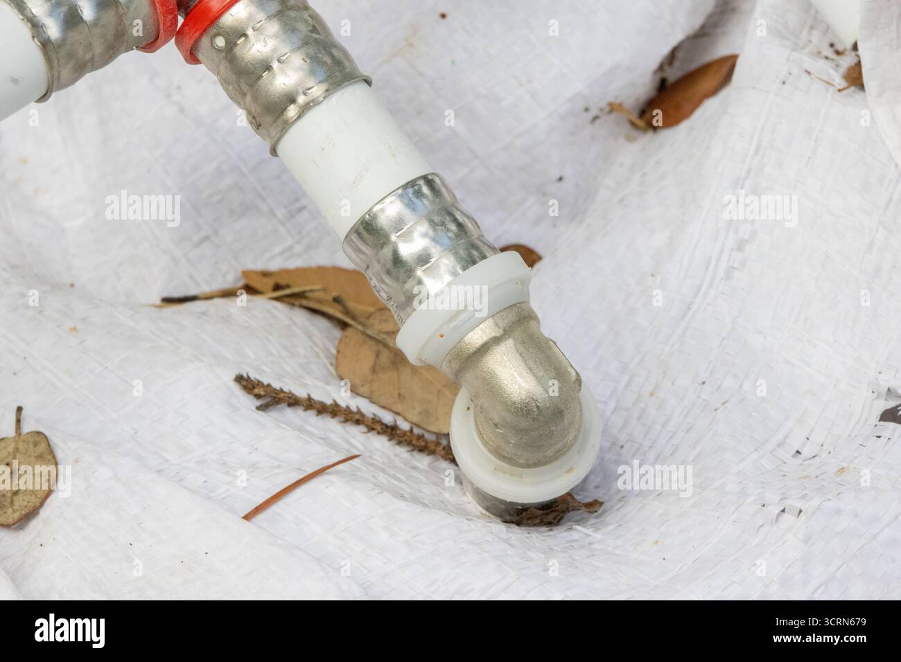 Gros plan sur les nouvelles conduites d'eau installées à l'aide d'un système de sertissage moderne, assurant une connexion sûre et sans fuite Banque D'Images