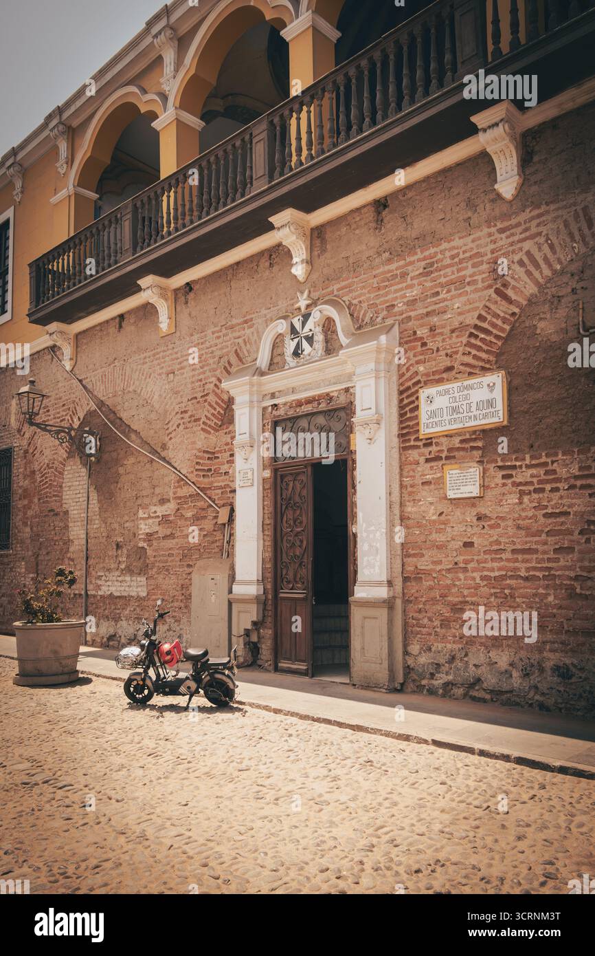 Bâtiment historique avec balcon voûté et moto à Lima, Pérou. Banque D'Images