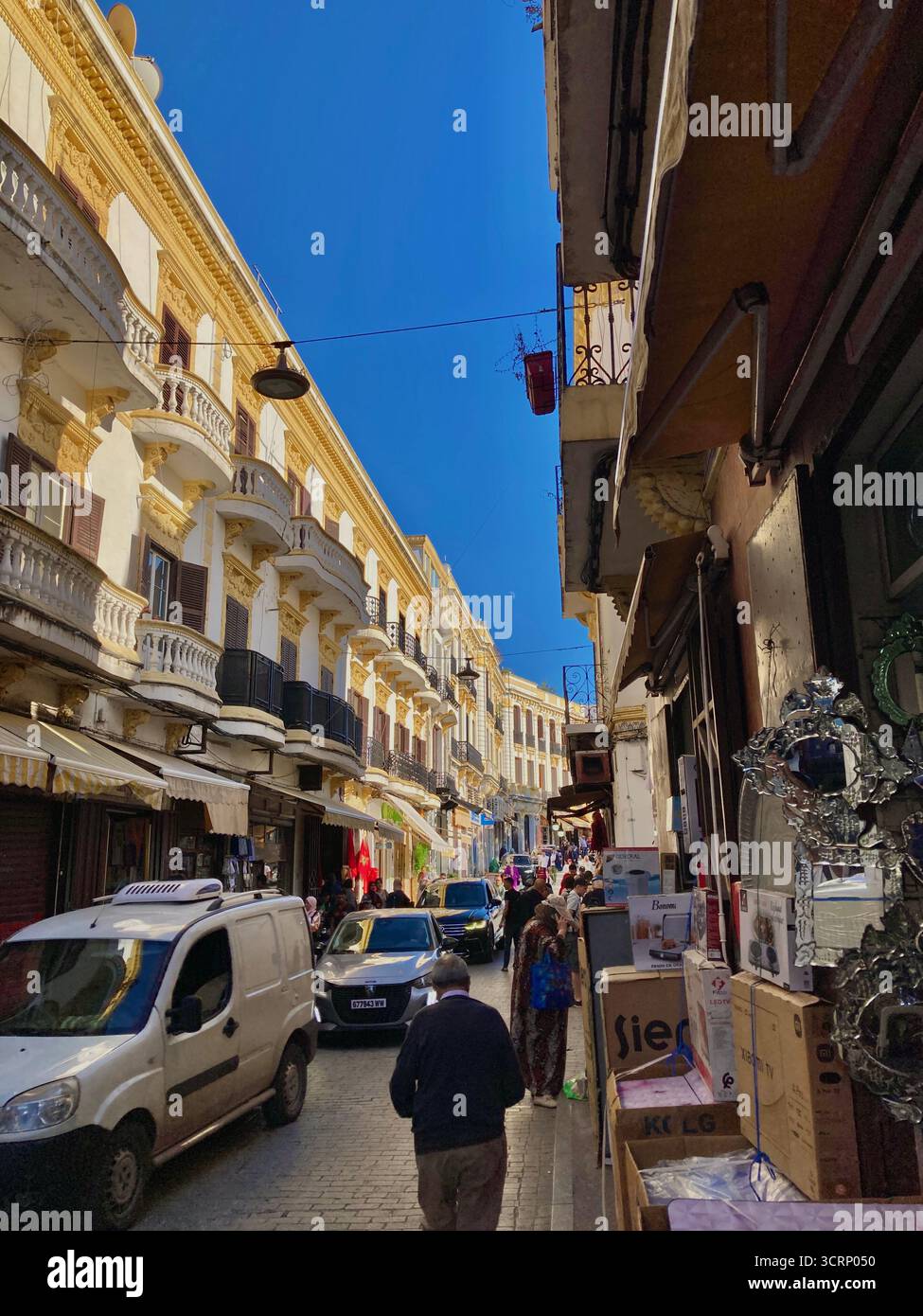 Scène de rue méditerranéenne animée avec balcons ornés, boutiques et piétons. Photographié le 1er octobre 2025 à Tanger, Maroc. Banque D'Images