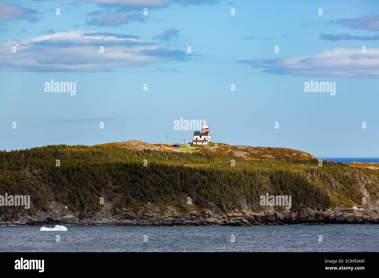 Un phare se trouve au sommet d'une colline surplombant l'océan, guidant les navires et offrant une vue panoramique pour les visiteurs. Banque D'Images