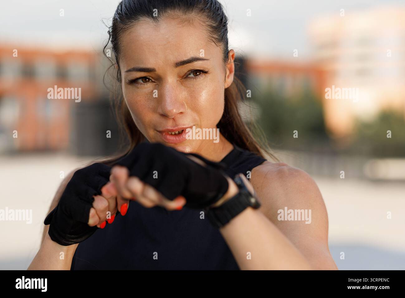 Portrait en gros plan détaillé d'une femme avec des gants debout à l'extérieur dans une position de combat Banque D'Images