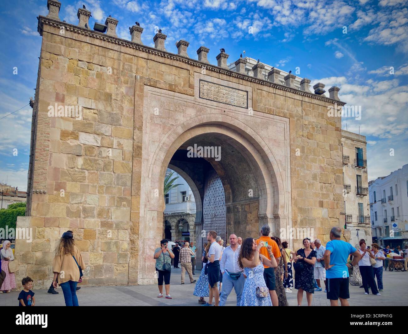 La porte de la ville de Bab El Bhar dans la vieille médina de Tunis, Tunisie, illuminée la nuit par la vie de la fontaine et de la rue. Capturé en septembre 2025. Banque D'Images