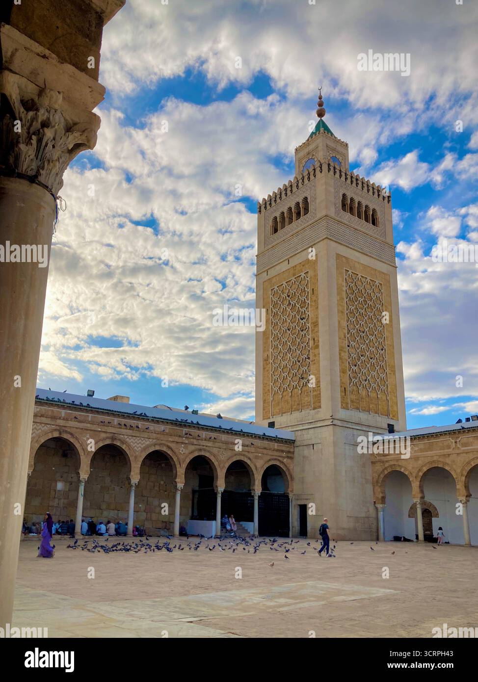 Cour de la mosquée Zitouna à Tunis, Tunisie - colonnades voûtées et minaret encadrés par une arche de pierre. Photographié le 24 septembre 2025. Banque D'Images