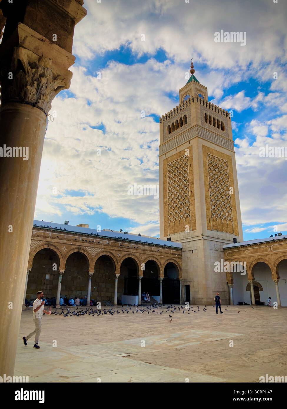 Cour de la mosquée Zitouna à Tunis, Tunisie - colonnades voûtées et minaret encadrés par une arche de pierre. Photographié le 24 septembre 2025. Banque D'Images