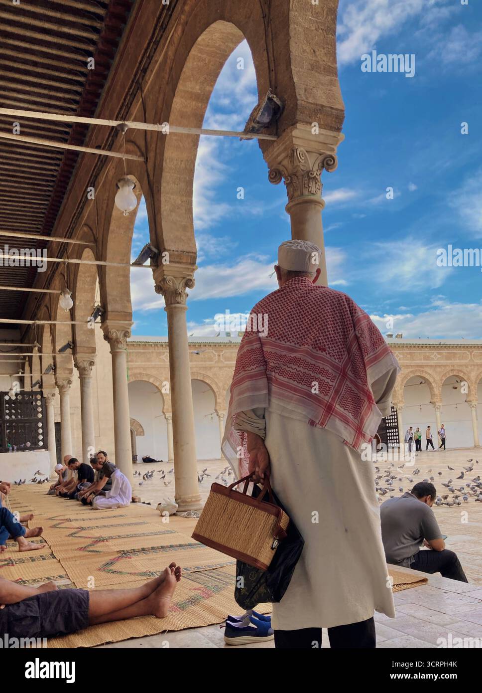 Cour de la mosquée Zitouna à Tunis, Tunisie - colonnades voûtées et minaret encadrés par une arche de pierre. Photographié le 24 septembre 2025. Banque D'Images