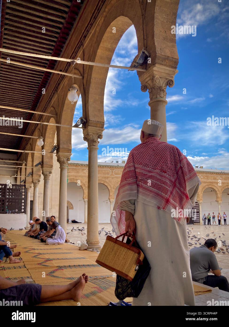 Cour de la mosquée Zitouna à Tunis, Tunisie - colonnades voûtées et minaret encadrés par une arche de pierre. Photographié le 24 septembre 2025. Banque D'Images