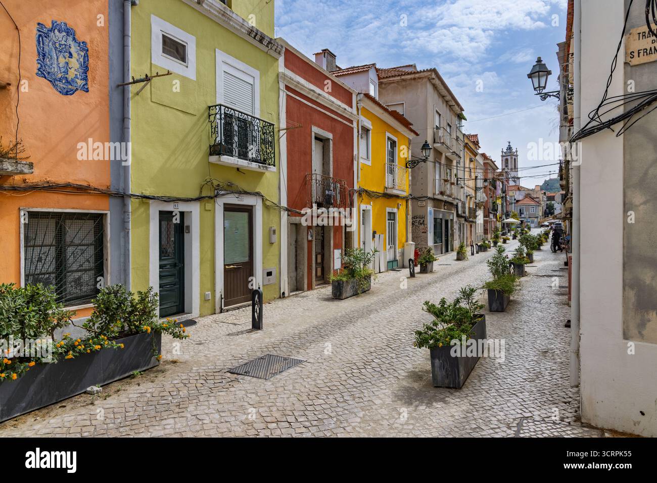 Une rue pavée dans le centre historique de Setubal est bordée de charmants bâtiments traditionnels avec des façades colorées peintes en jaune, orange, Banque D'Images