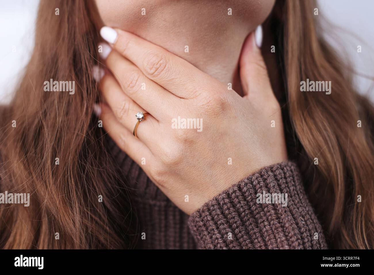 Jeune femme touchant le cou souffrant de mal de gorge. Symptôme de rhume ou de grippe avec douleur dans les amygdales. Problème de santé et concept de maladie saisonnière. Banque D'Images