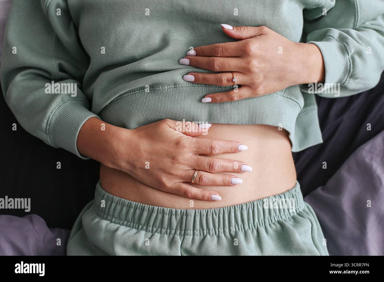 Femme tenant le ventre avec les deux mains. Concept de douleur et d'inconfort abdominaux. Santé, digestion et crampes périodiques thème. Banque D'Images