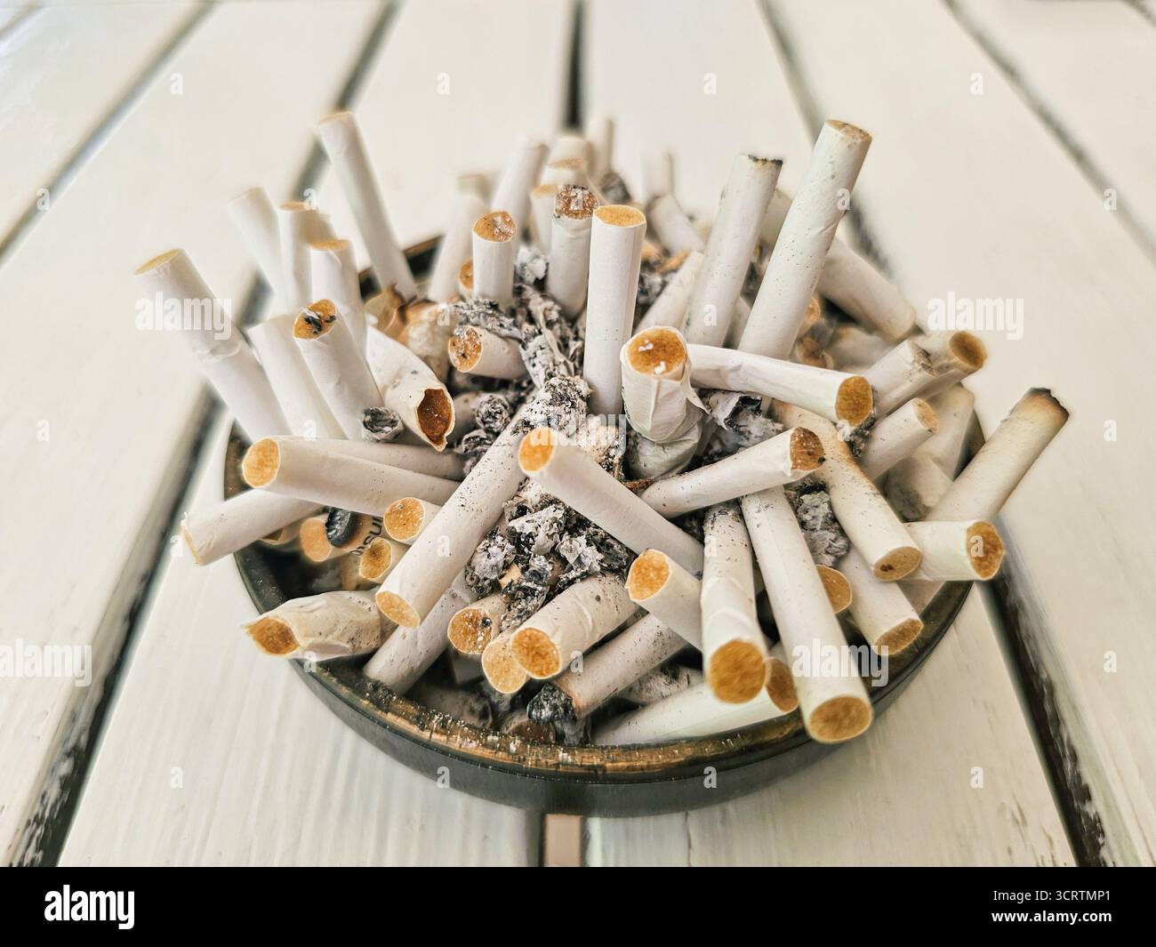 La cendre de cigarette dans un cendrier et allume close up Photo