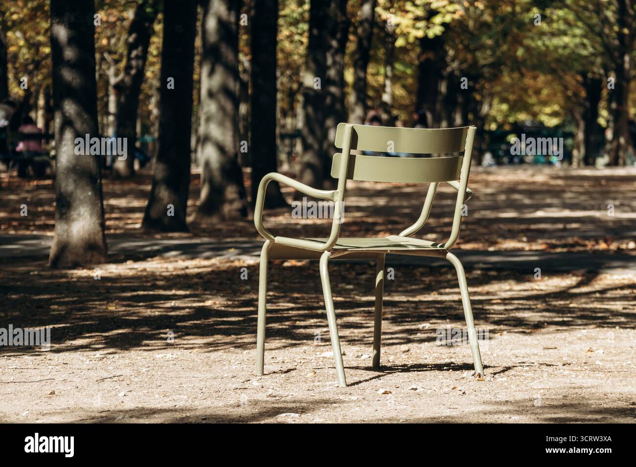 Des chaises emblématiques en métal vert se tiennent vides sur un chemin de gravier ensoleillé dans le célèbre parc de la ville - jardin du Luxembourg, Paris, France Banque D'Images