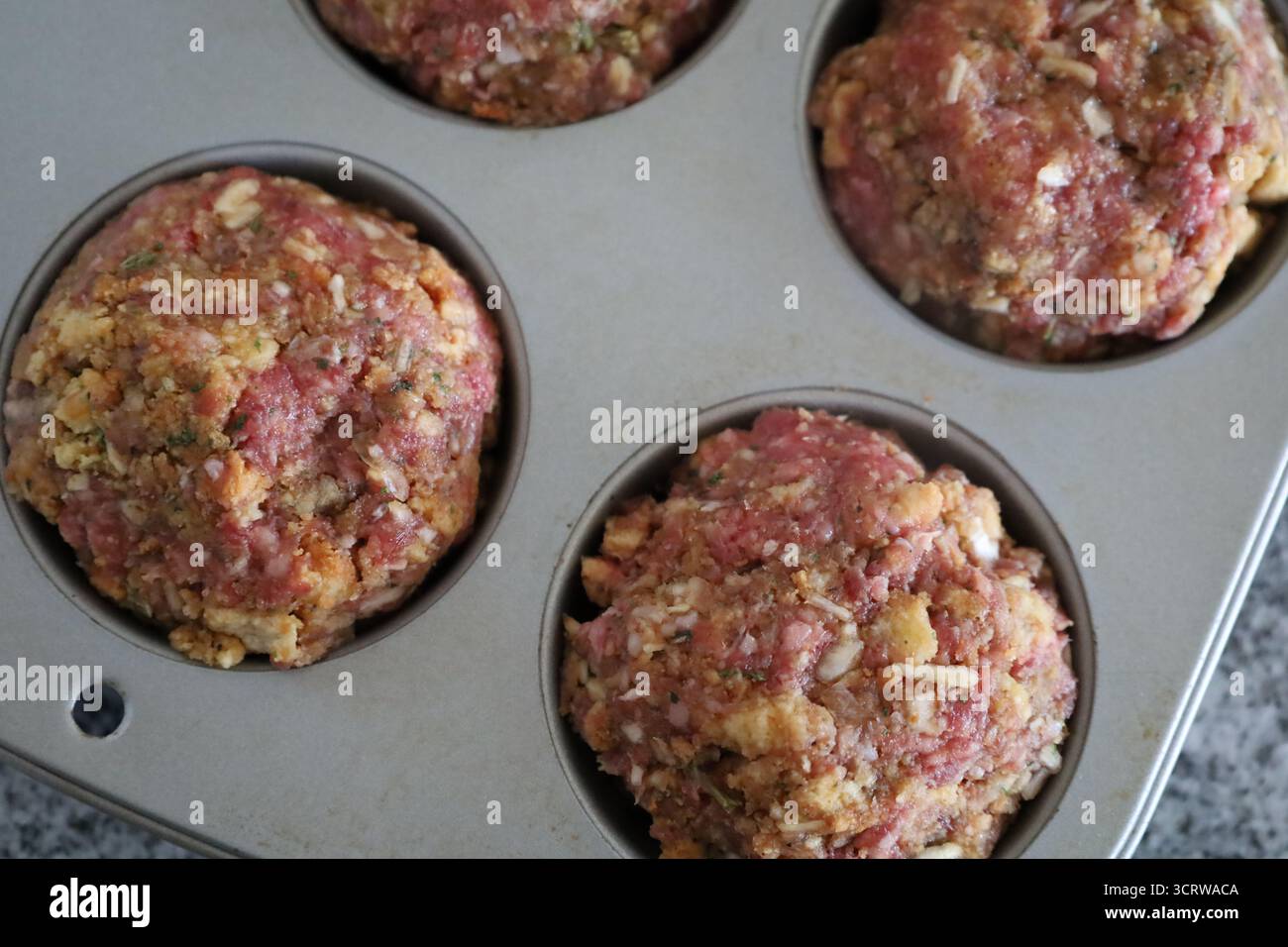 Muffins crus de pain de viande dans une boîte à muffins en métal Banque D'Images