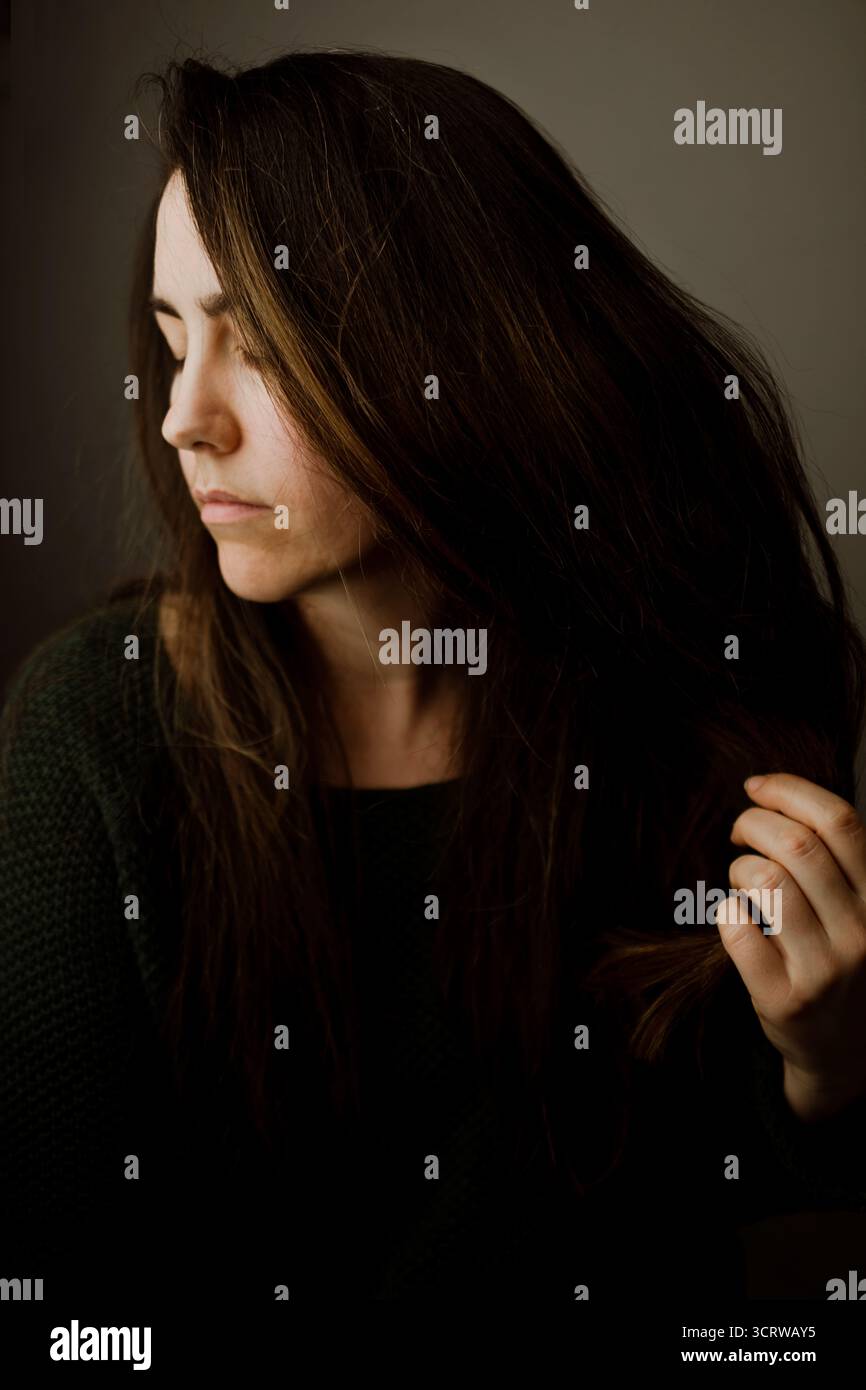 Femme en profil avec les yeux fermés et la main dans les cheveux Banque D'Images