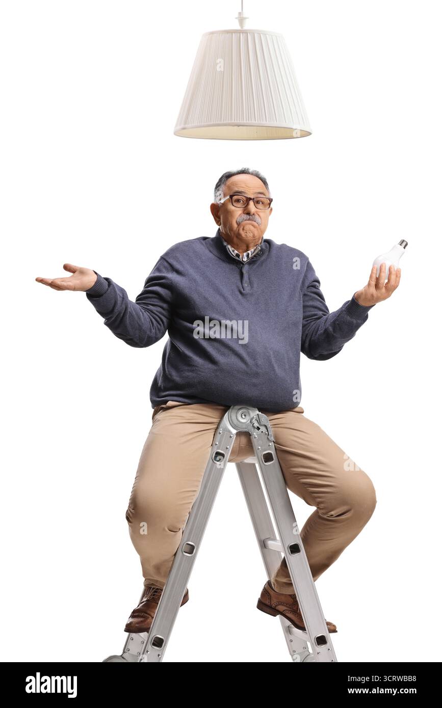Homme mûr confus tenant un luminaire à ampoule et assis sur une échelle isolé sur fond blanc Banque D'Images