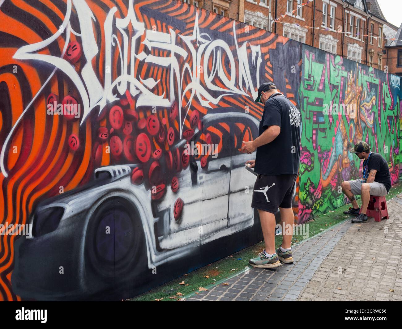 Street Art à Southend Graffiti artiste peignant des dessins animés de voiture à City Jam Banque D'Images