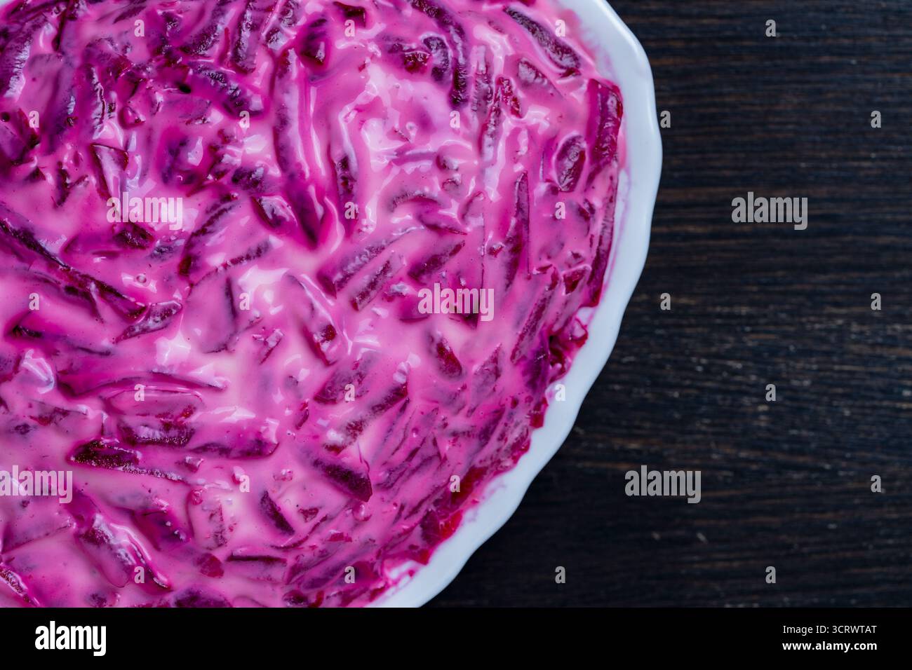 Salade ukrainienne traditionnelle dans une assiette appelée hareng sous un manteau de fourrure ou shuba sur une table en bois, gros plan, vue de dessus Banque D'Images