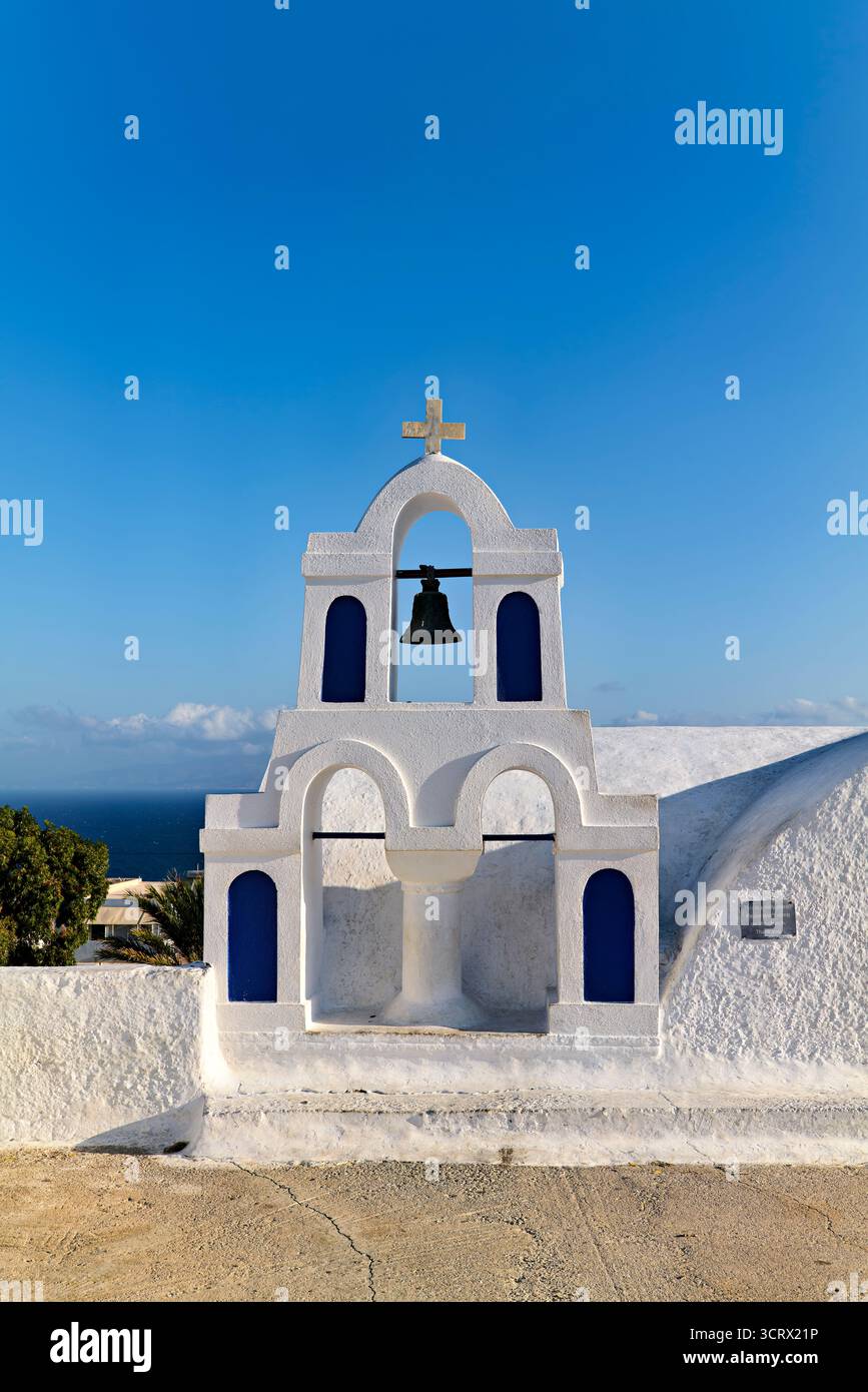 Santorin Grèce. Oia. Une église classique de style architectural des Cyclades avec un clocher et des fenêtres cintrées se dresse contre un ciel bleu clair Banque D'Images