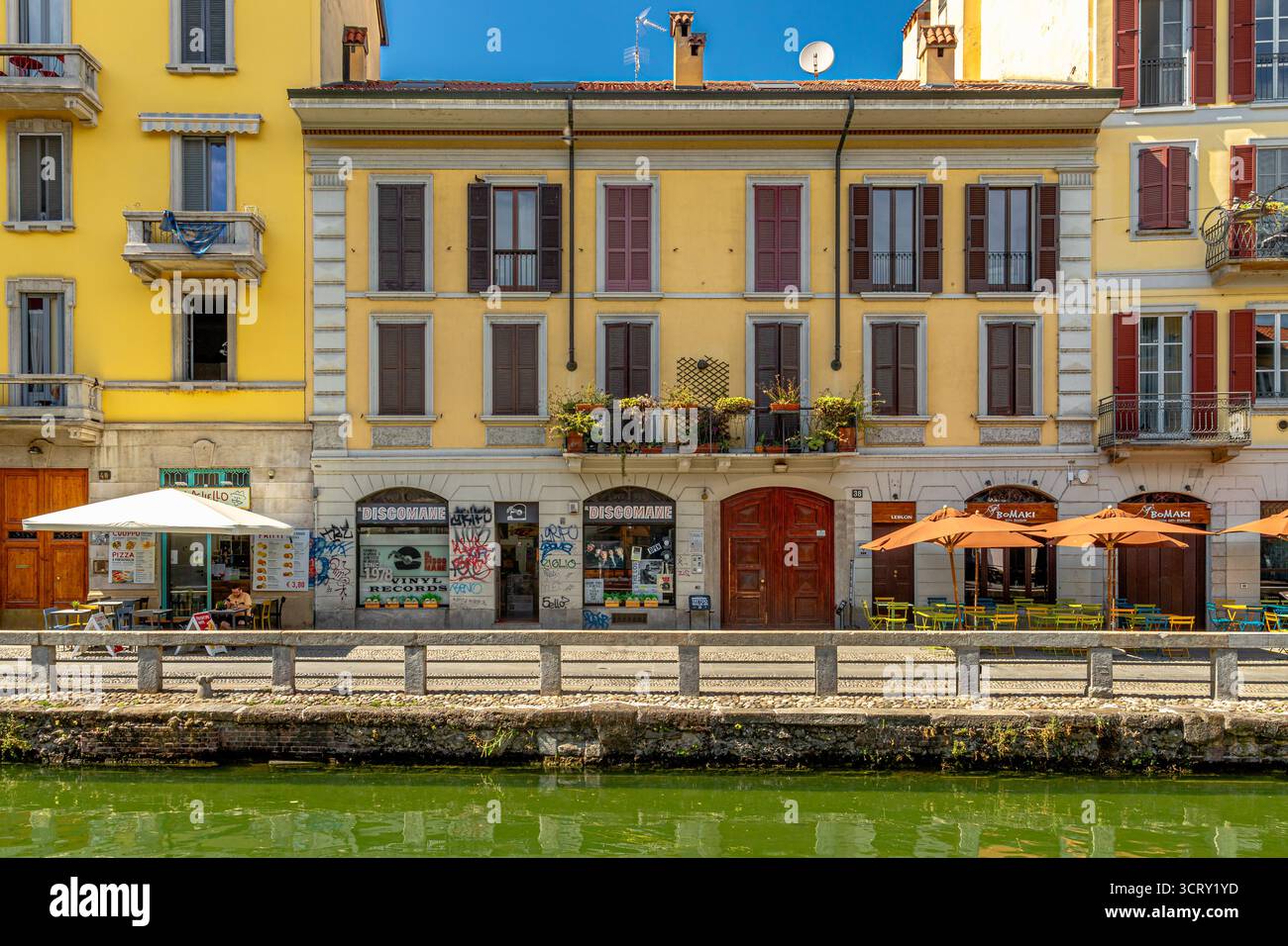 Bars et restaurants bordent le canal le long d'Alzaia Naviglio Grande dans le quartier du canal Navigli, Milan, Italie Banque D'Images