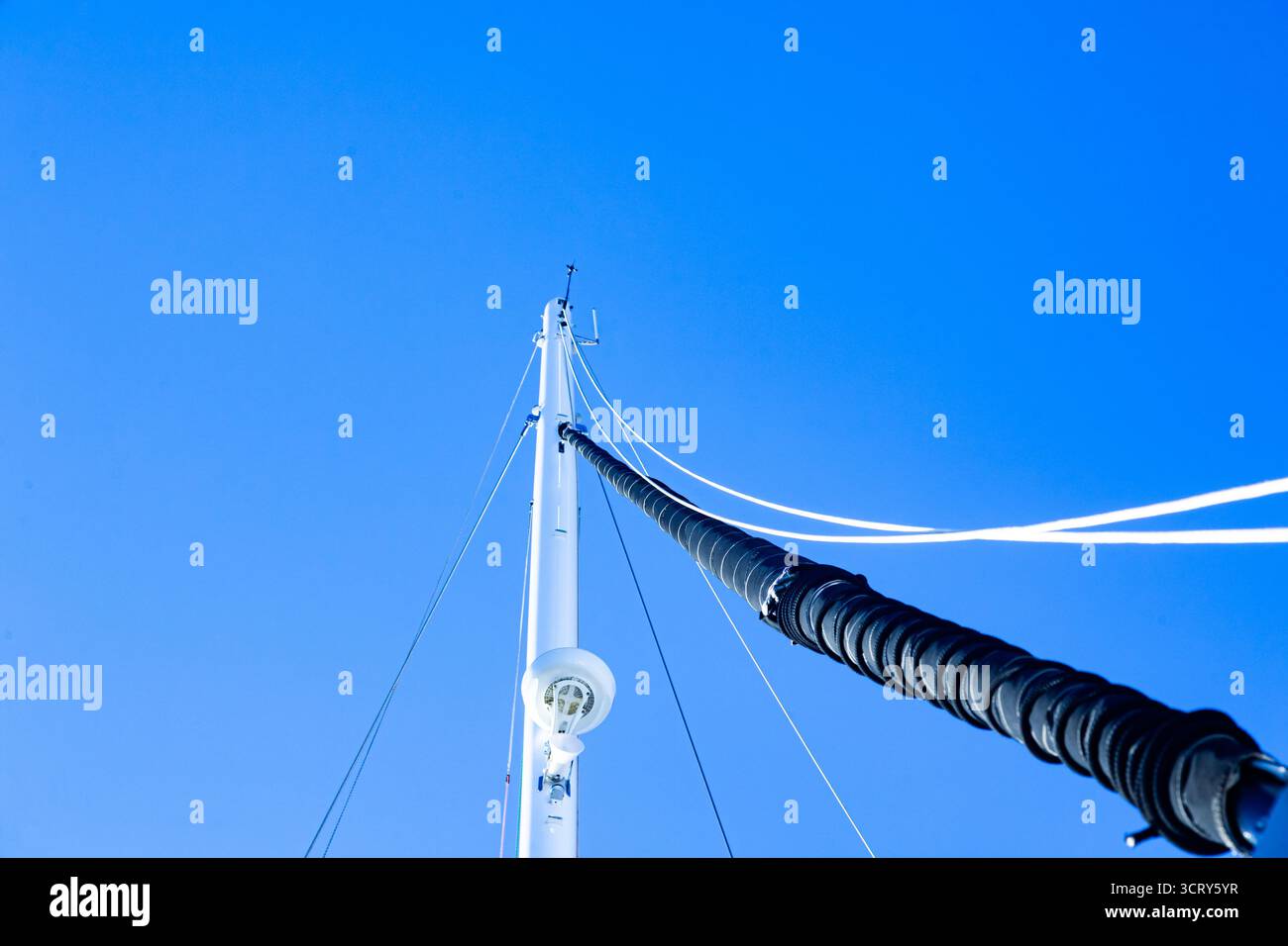 Mât de yacht à voile avec radar, haut-parleur sur le dessus, cordes à voile et voile pliée, vue d'en bas. Banque D'Images