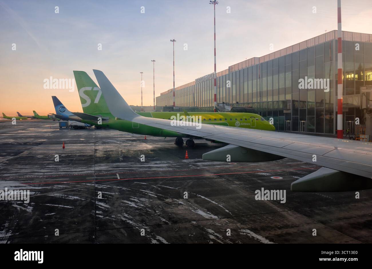 Novossibirsk, Russie - 15 janvier 2025 : avion vert de S7 Airlines stationné à l'aéroport moderne à Sunrize avec le sol givré du terrain de décollage de l'aérodrome Banque D'Images