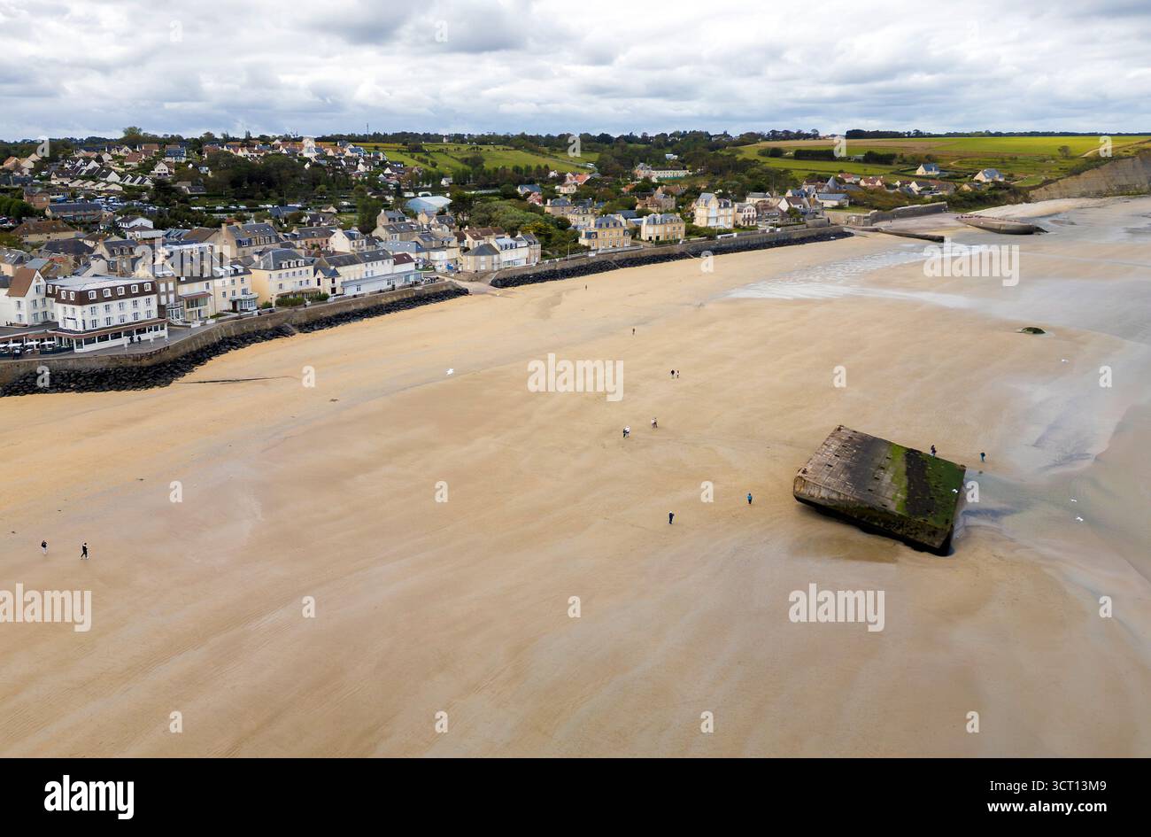 Les gens marchent à marée basse autour des vestiges de Mulberry Harbour sur la plage d'Arromanches-les-bains, Normandie, France Banque D'Images