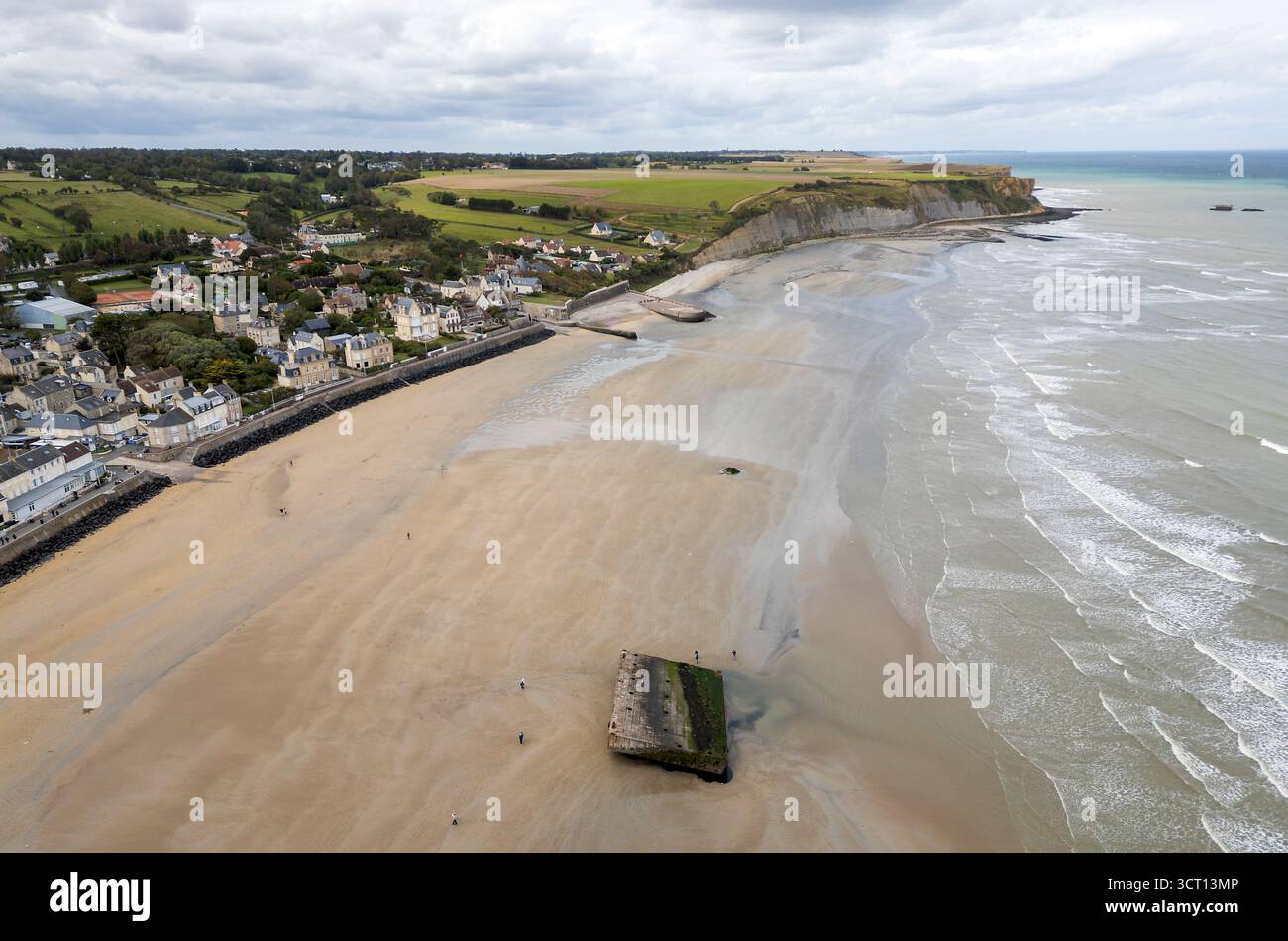 Les gens marchent à marée basse autour des vestiges de Mulberry Harbour sur la plage d'Arromanches-les-bains, Normandie, France Banque D'Images