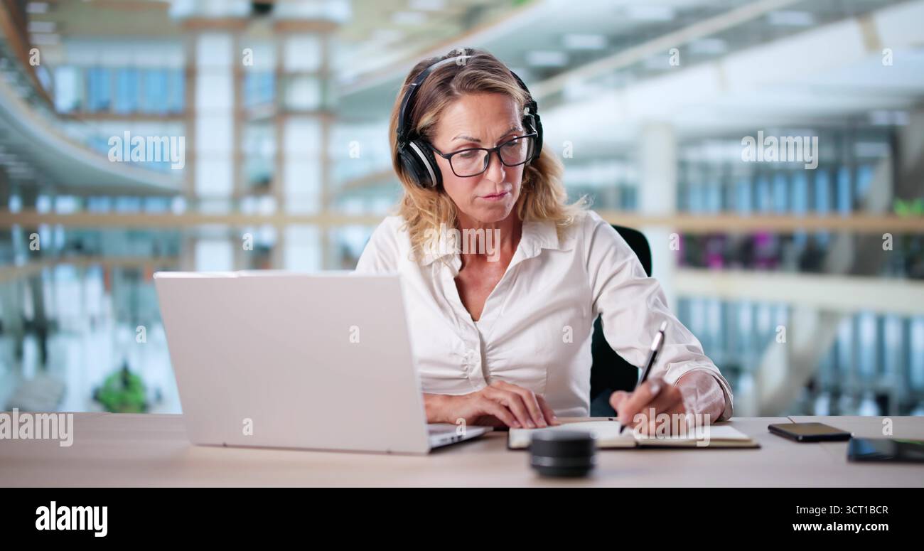 Femme étudiant en ligne sur ordinateur portable avec casque Banque D'Images