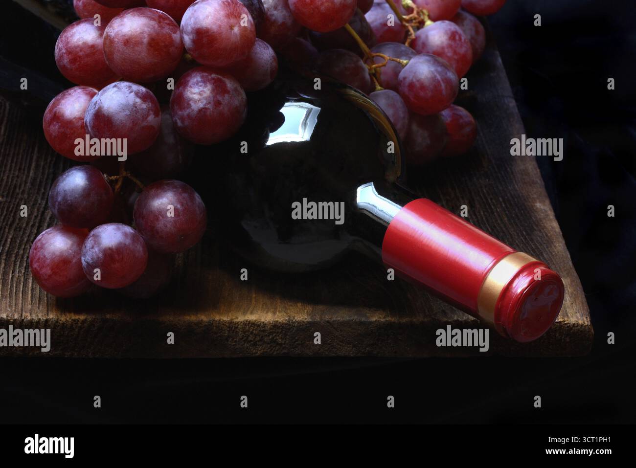 Raisins rouges avec bouteille de vin rouge Banque D'Images