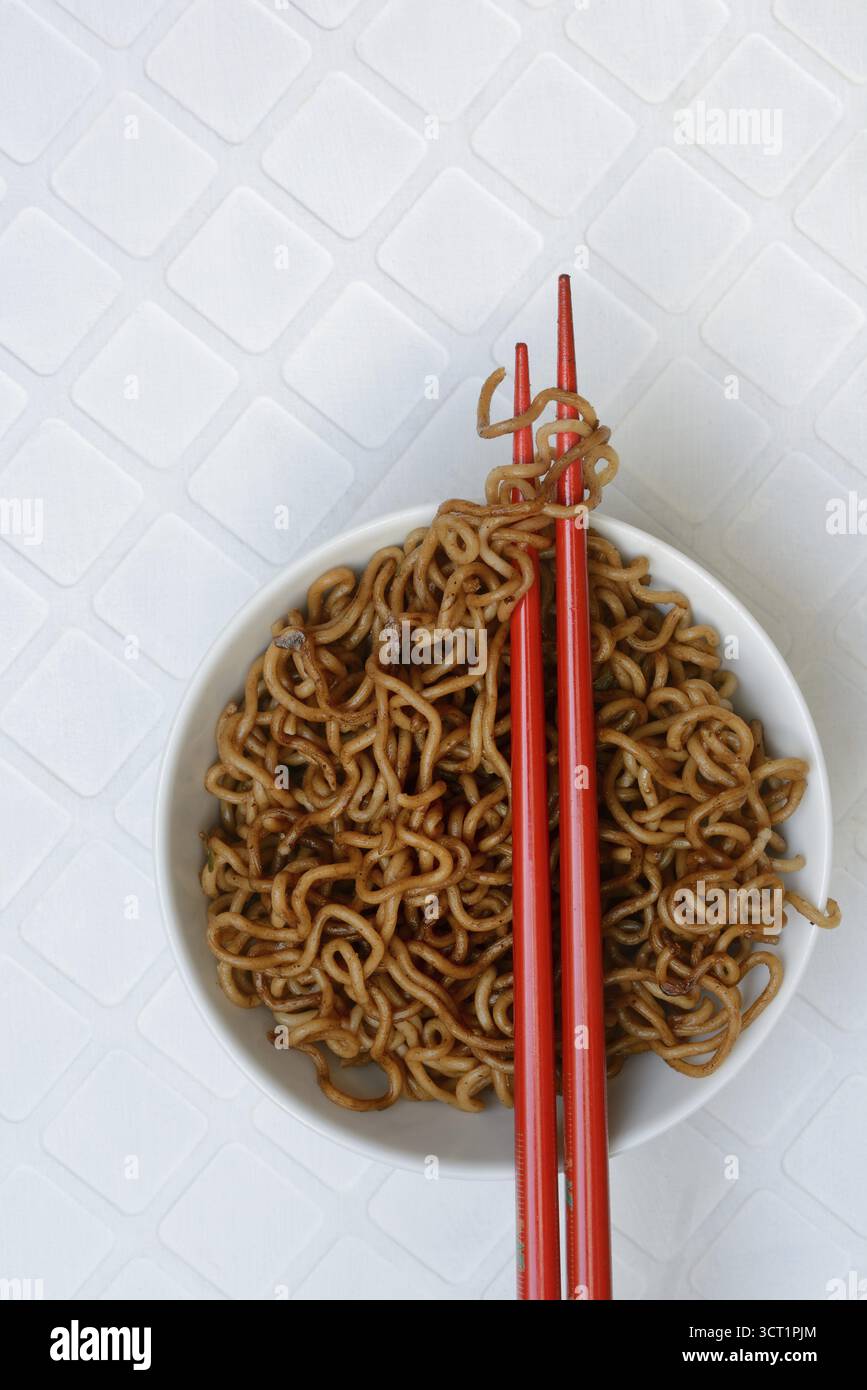 Bol de nouilles asiatiques et baguettes, cuites, nouilles Mie Banque D'Images