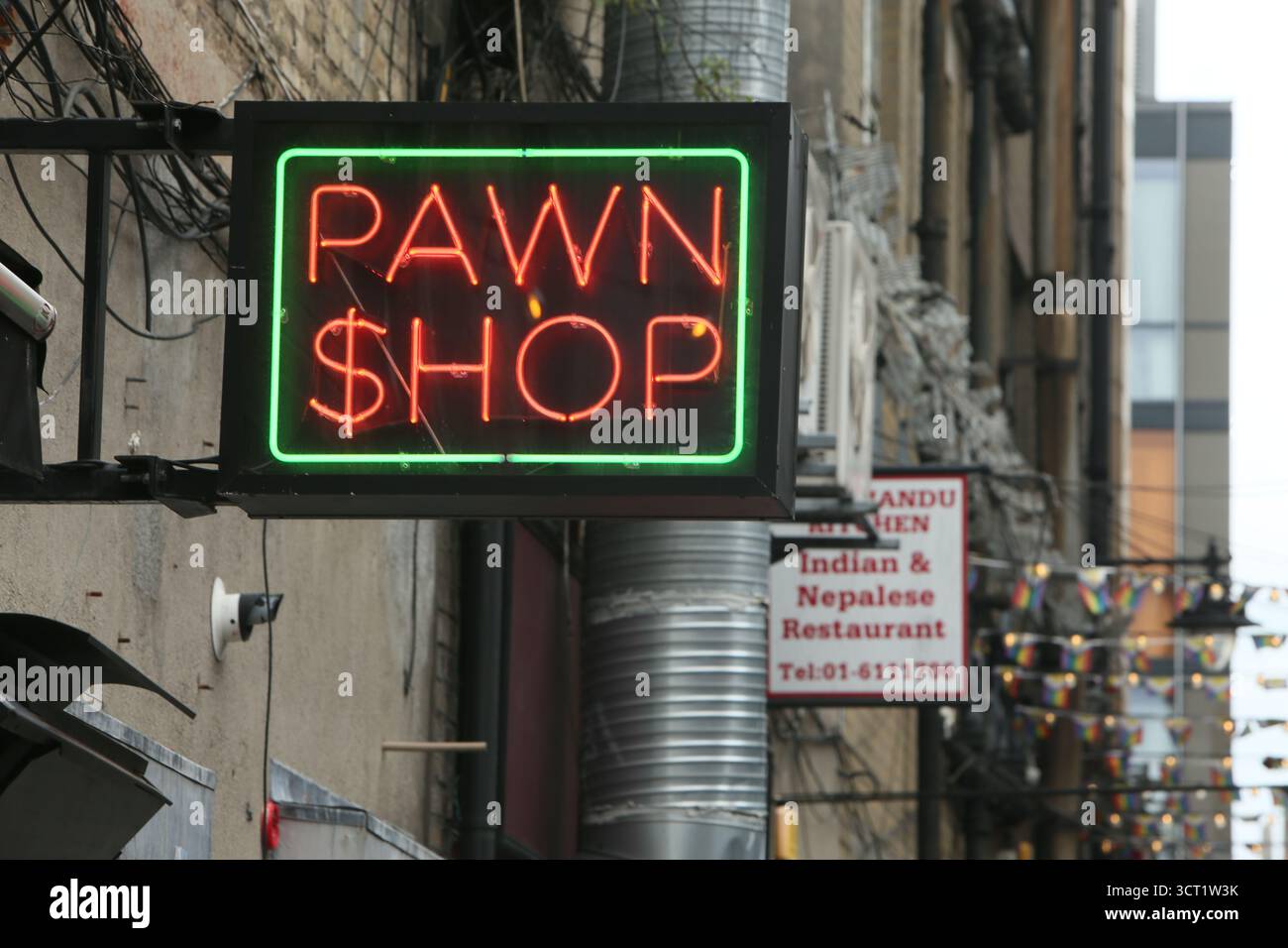 Dublin, Irlande - 29 août 2025 - Un néon rouge et vert illumine le panneau 'Pawn Shop' dans une ruelle du centre-ville de Dublin par un après-midi sec et doux Banque D'Images