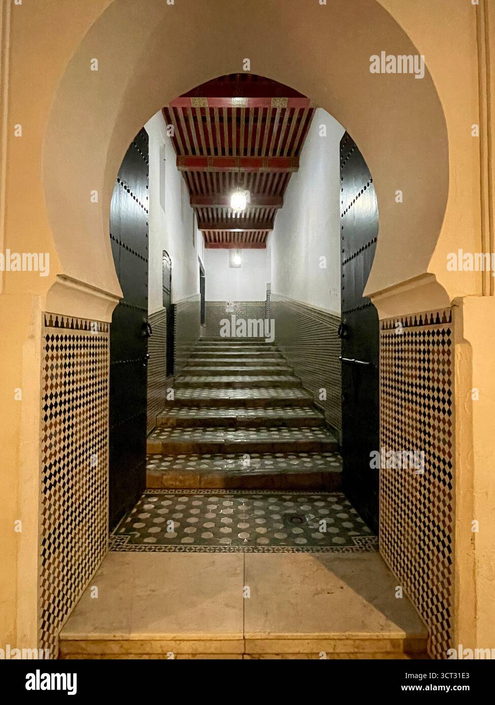 Entrée intérieure d'une mosquée dans l'ancienne médina de Tanger, Maroc. Portes arquées, tapis rouge et design islamique traditionnel. Tournage : 3 octobre 2025. Banque D'Images