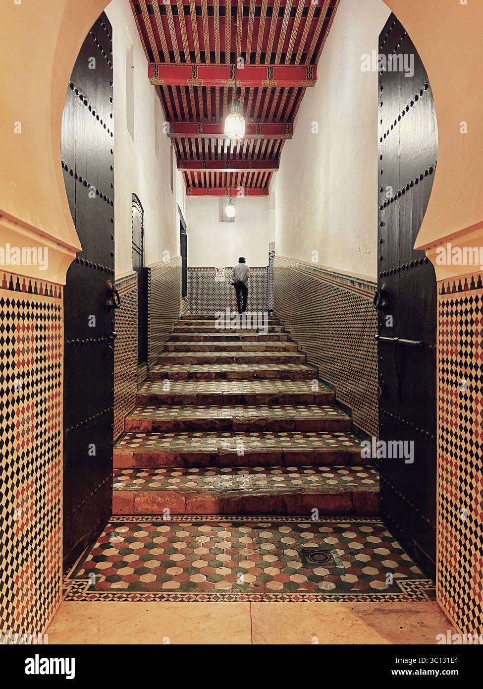 Entrée intérieure d'une mosquée dans l'ancienne médina de Tanger, Maroc. Portes arquées, tapis rouge et design islamique traditionnel. Tournage : 3 octobre 2025. Banque D'Images