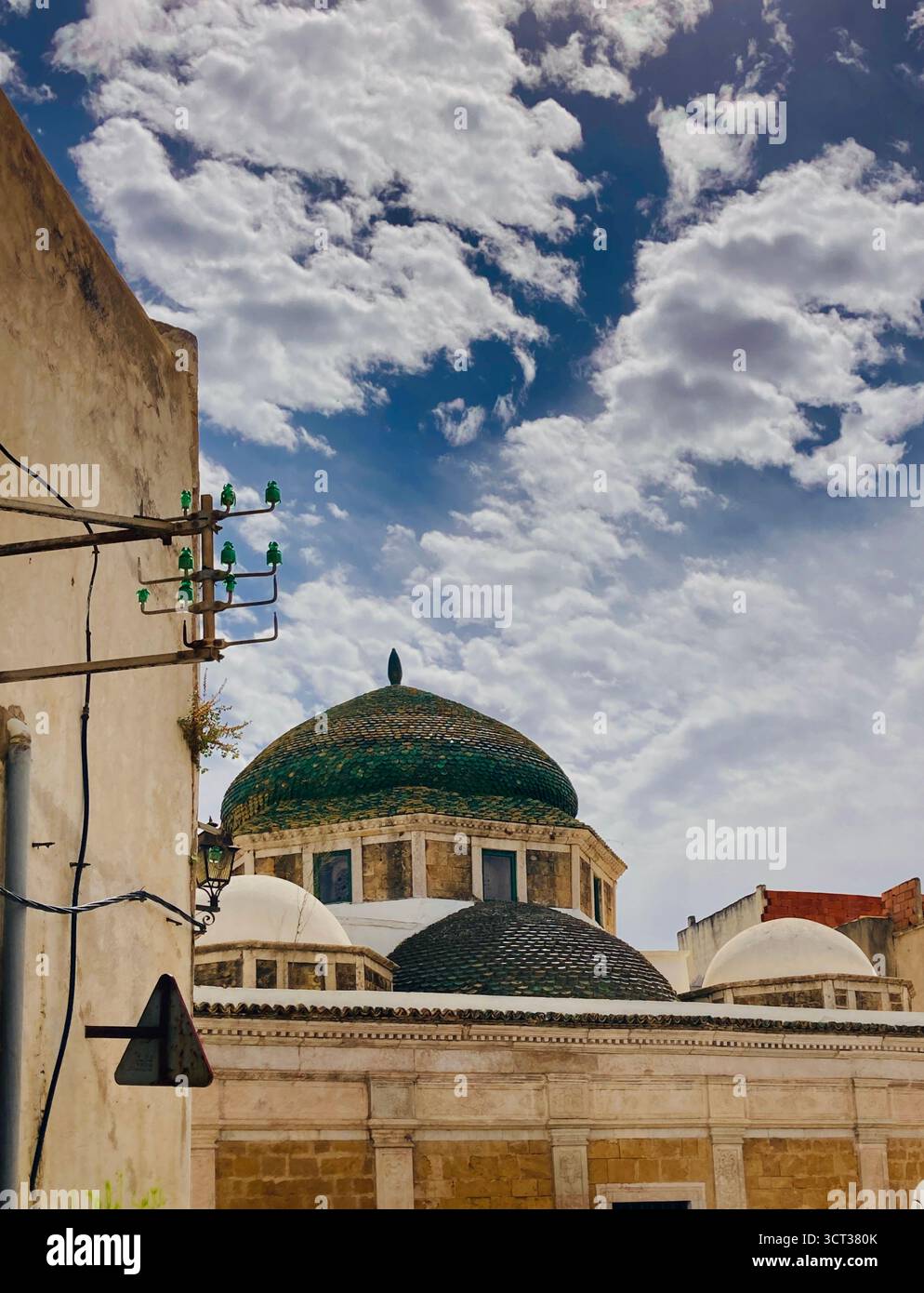 Mosquée islamique et école à Tunis, Tunisie. Dôme carrelé vert, façade en pierre sculptée et détails architecturaux traditionnels. Capturé le 22 septembre 2025 Banque D'Images
