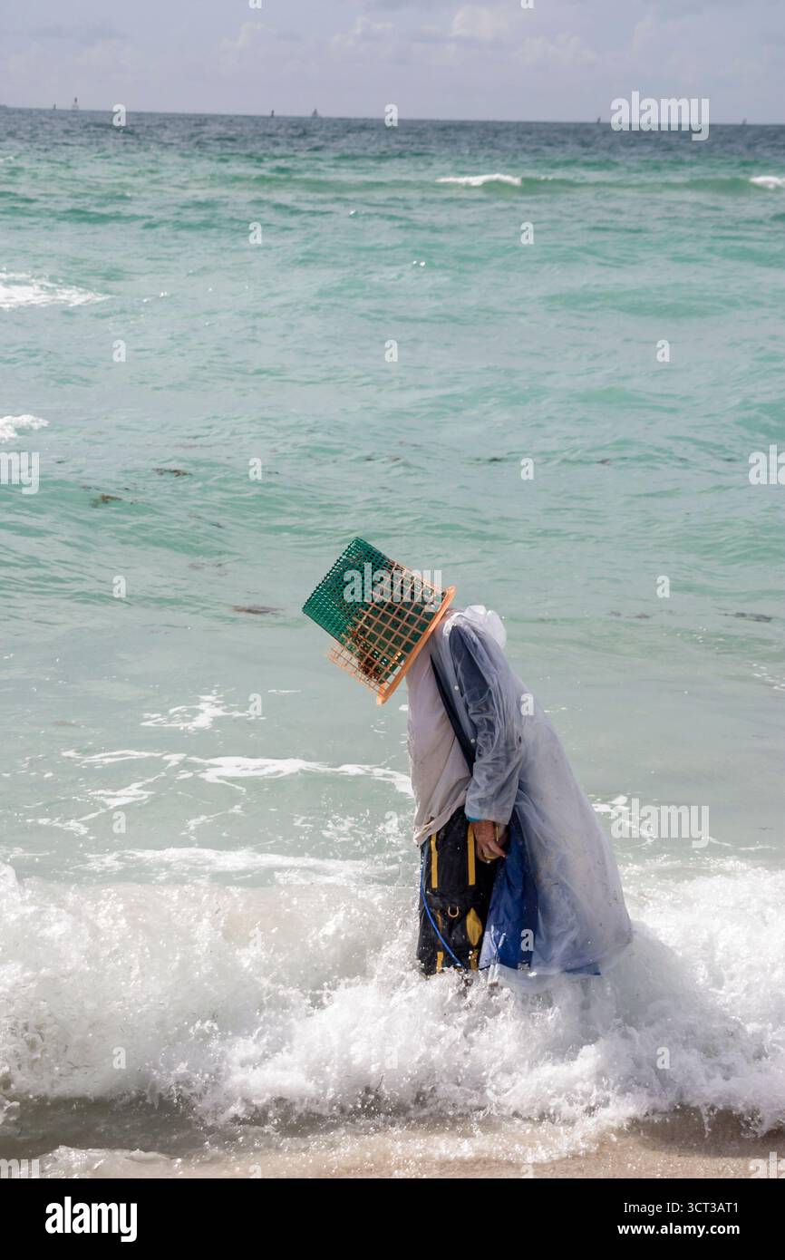 Miami Beach Florida,mentalement malade vagant,sans-abri,mendiant,bum,vagabond,sans-emploi,addict,porte le panier sur la tête et parle à soi, les visiteurs Voyage Voyage Voyage Voyage Voyage Voyage dans Banque D'Images