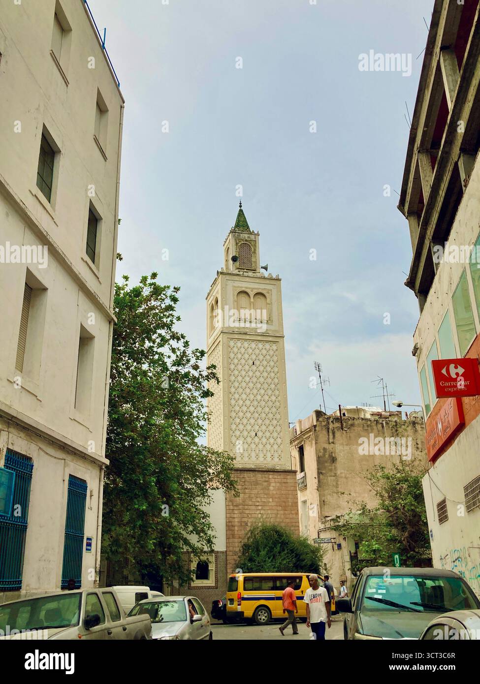 Vue sur la rue d'une mosquée dans le centre de Tunis, Tunisie. Minaret traditionnel, architecture urbaine et vie quotidienne dans la rue. Capturé le 22 septembre 2025. Banque D'Images