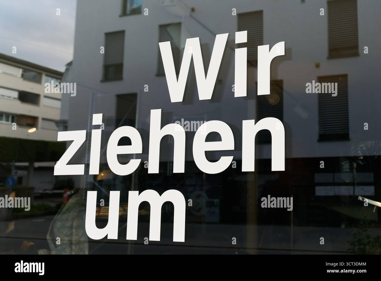 Lettrage avec les mots allemands wir ziehen um, devant une vitrine en Allemagne. Traduction : nous bougeons Banque D'Images