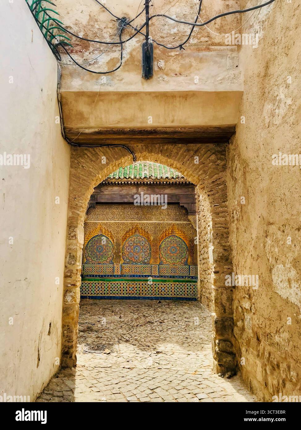 Entrée en pierre voûtée menant à une cour carrelée dans la vieille médina de Tanger, Maroc. Photographié le 8 novembre 2019. Banque D'Images