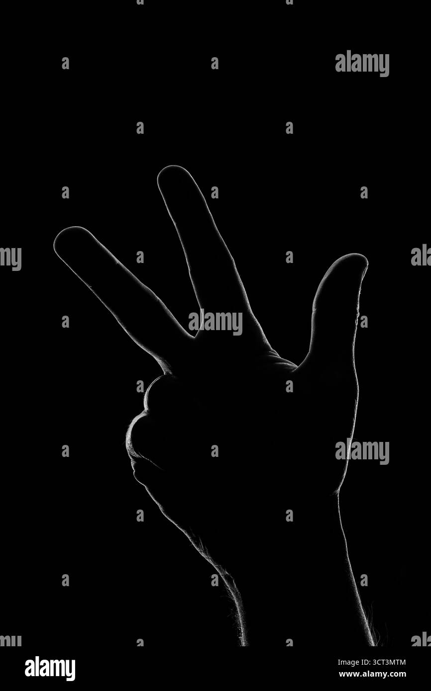 La silhouette de trois doigts de la main en chiaroscuro Banque D'Images
