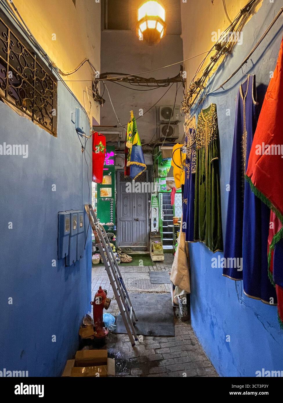 Ruelles étroites et scènes de marché dynamiques à Tanger, Maroc. Architecture traditionnelle, murs bleus, produits artisanaux, lanternes chaudes. 2 OCTOBRE 2025 Banque D'Images