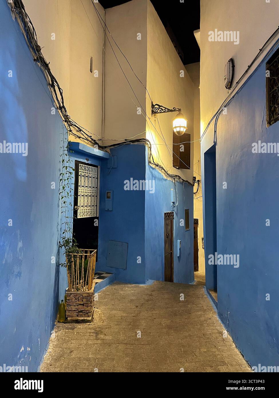 Étroite ruelle bleue à Tanger, Maroc. Architecture traditionnelle, murs bleus vibrants et lanterne chaleureuse. Capturé le 2 octobre 202 Banque D'Images